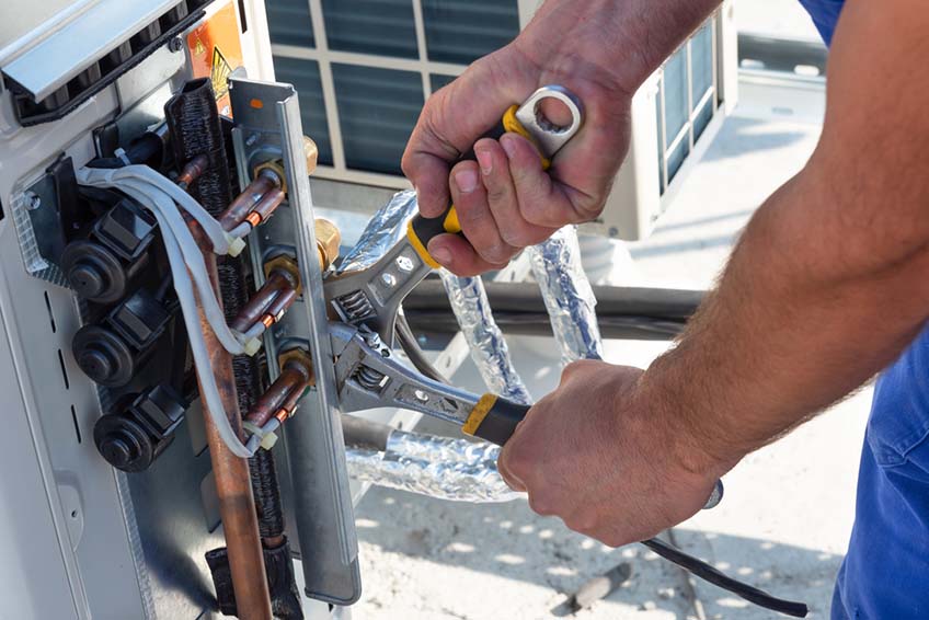 HVAC technician working on air conditioner units