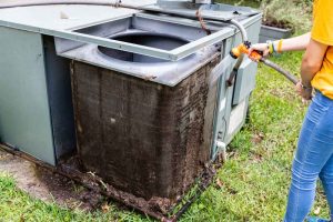 technician cleaning dirty HVAC unit