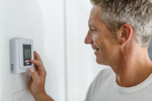 person adjusting the thermostat